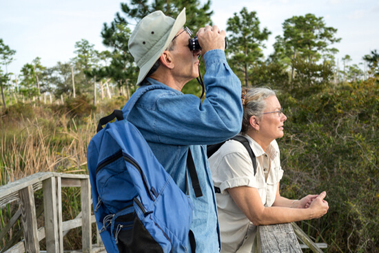Couple with binoculars observing nature