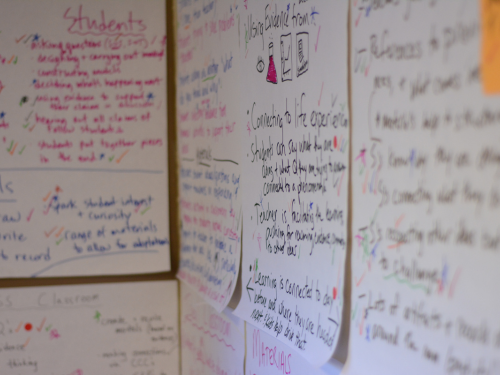 Image: Large Post-it notes on a wall with writing on them in colored marker.