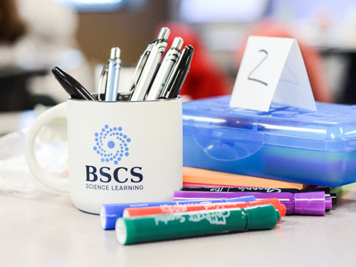 Coffee mug with BSCS Science Learning logo and pens inside