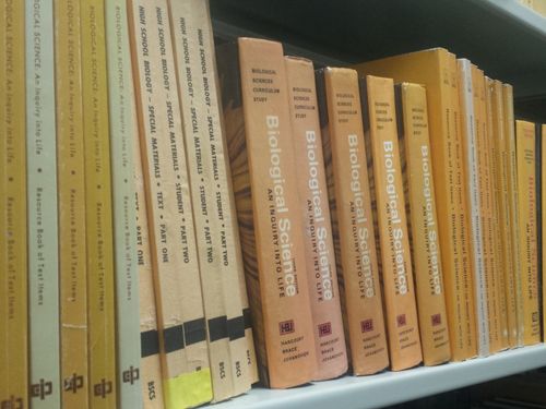 Bookshelf full of past BSCS biology books